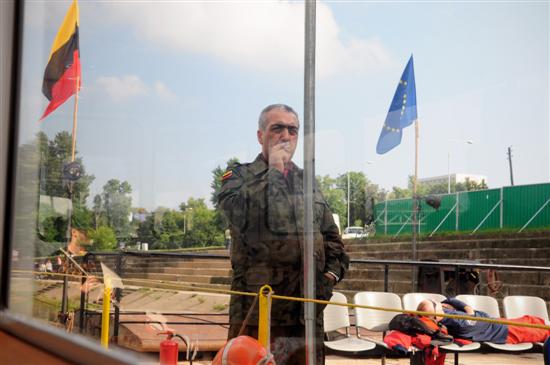 Border post officer, behind: flags: EU+ and Transkaukazja Confederation / Damien Brailly